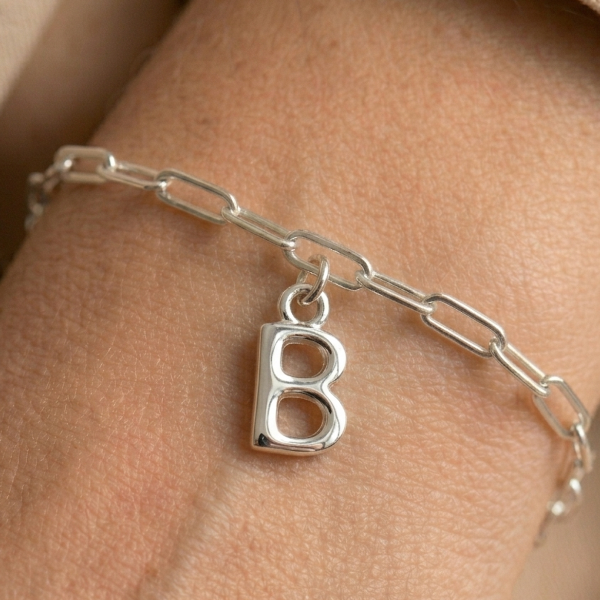 Silver necklace with a 'B' pendant on a person's neck