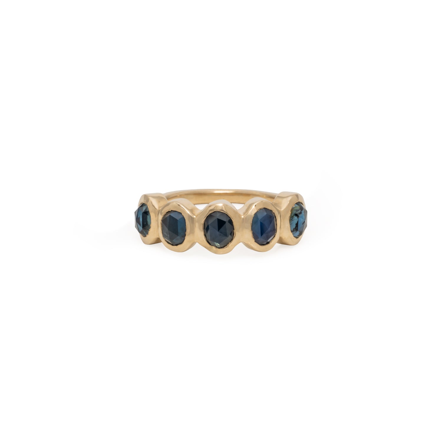 Gold ring with five blue sapphire gemstones on a white background