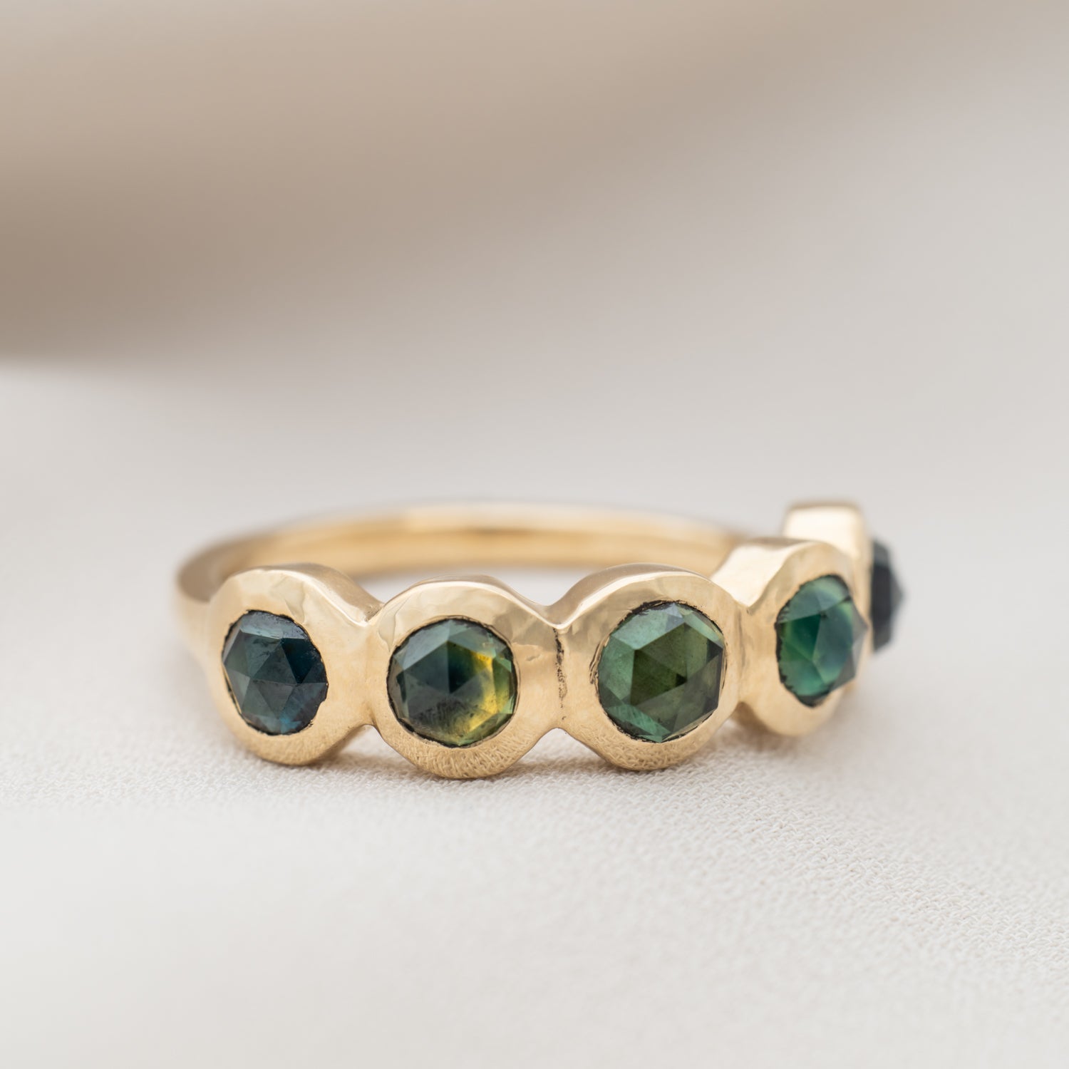 Gold ring with sapphire gemstones on a light background