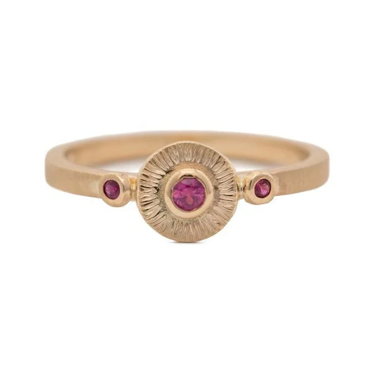 Solaris ruby ring in 14k gold with a textured sunburst disc and two small ruby accents, front view