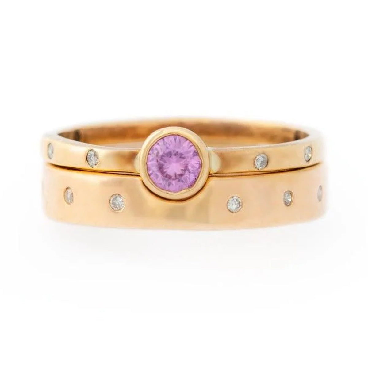 Ellie pink sapphire ring in gold with flush-set diamonds, stacked with a wider diamond-set band