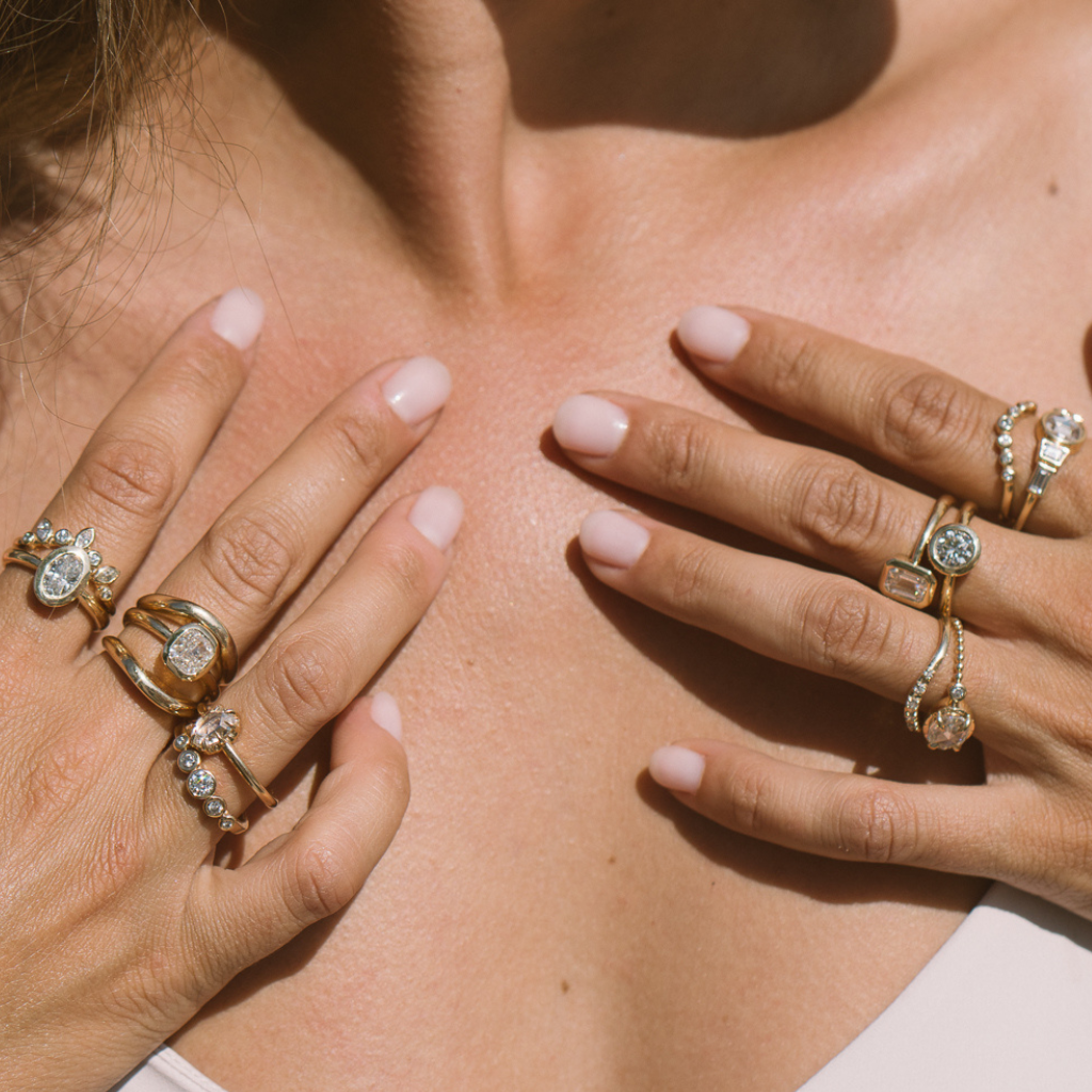 14k gold ready to ship engagement rings with diamonds stacked with wedding bands on womans hands.