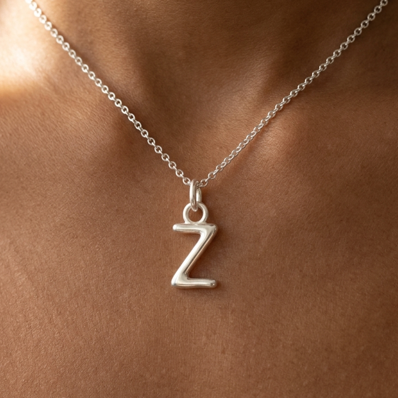 Silver necklace with a 'Z' pendant on a person's neck