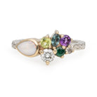 Cathy custom cluster ring with opal, green, teal and purple stones in gold on a patterned silver band