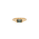 Gold ring with a sapphire gemstone on a white background