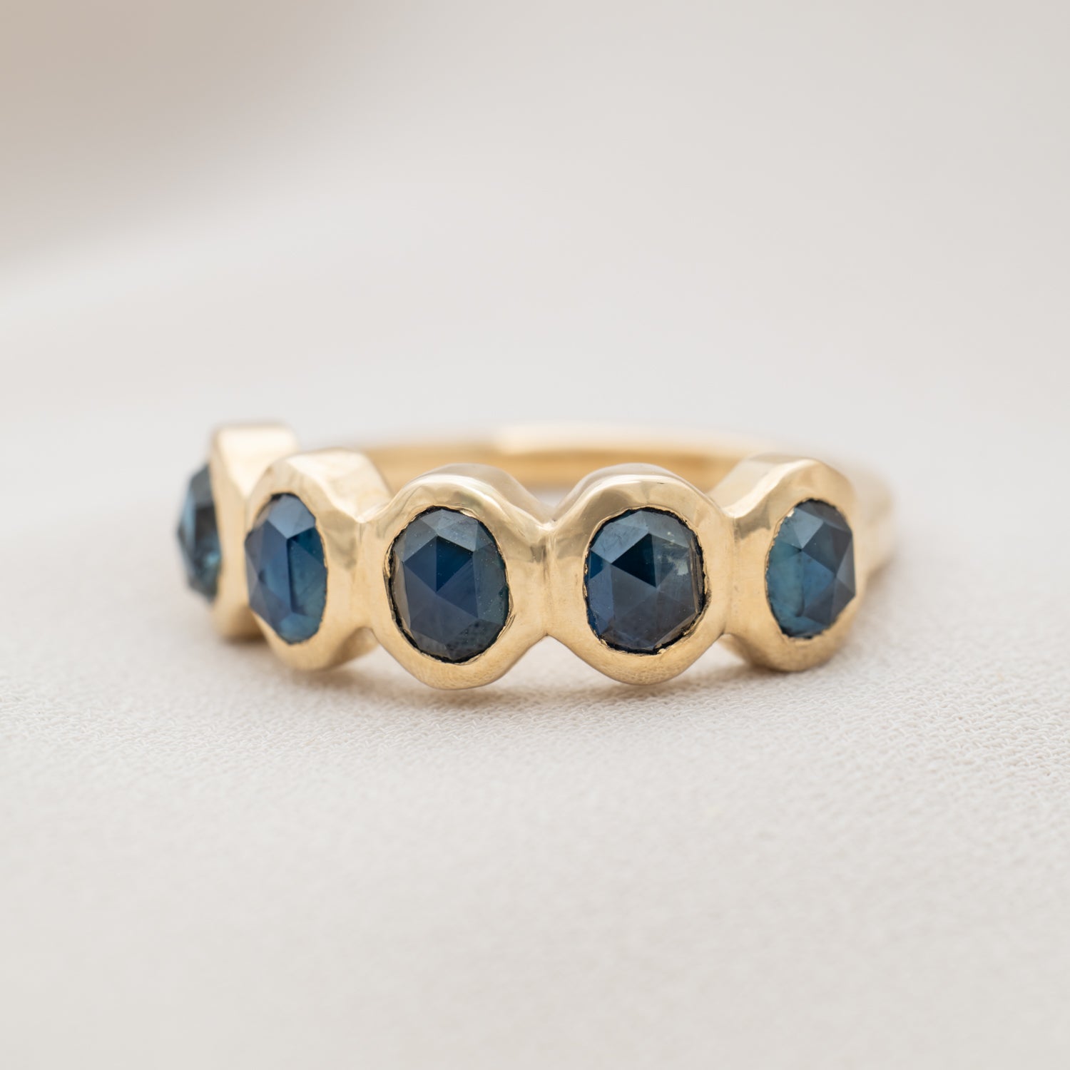 Gold ring with five blue sapphire gemstones