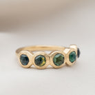 Gold ring with sapphire gemstones on a light background