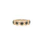 Gold ring with green gemstones on a white background