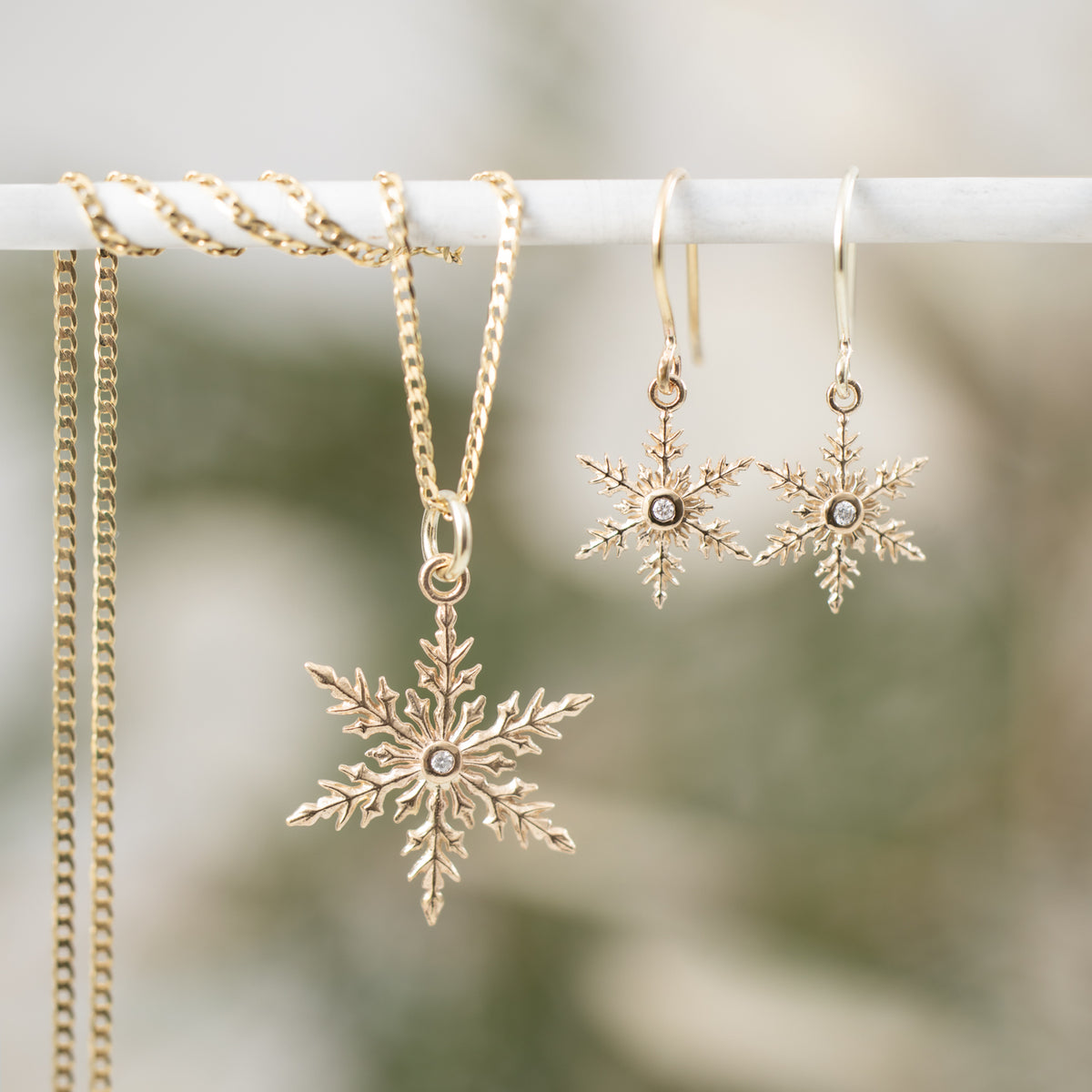 Kat Cadegan 2025 Snowflake 14k gold pendant with diamond on chain with small 14k gold snowflake earrings 