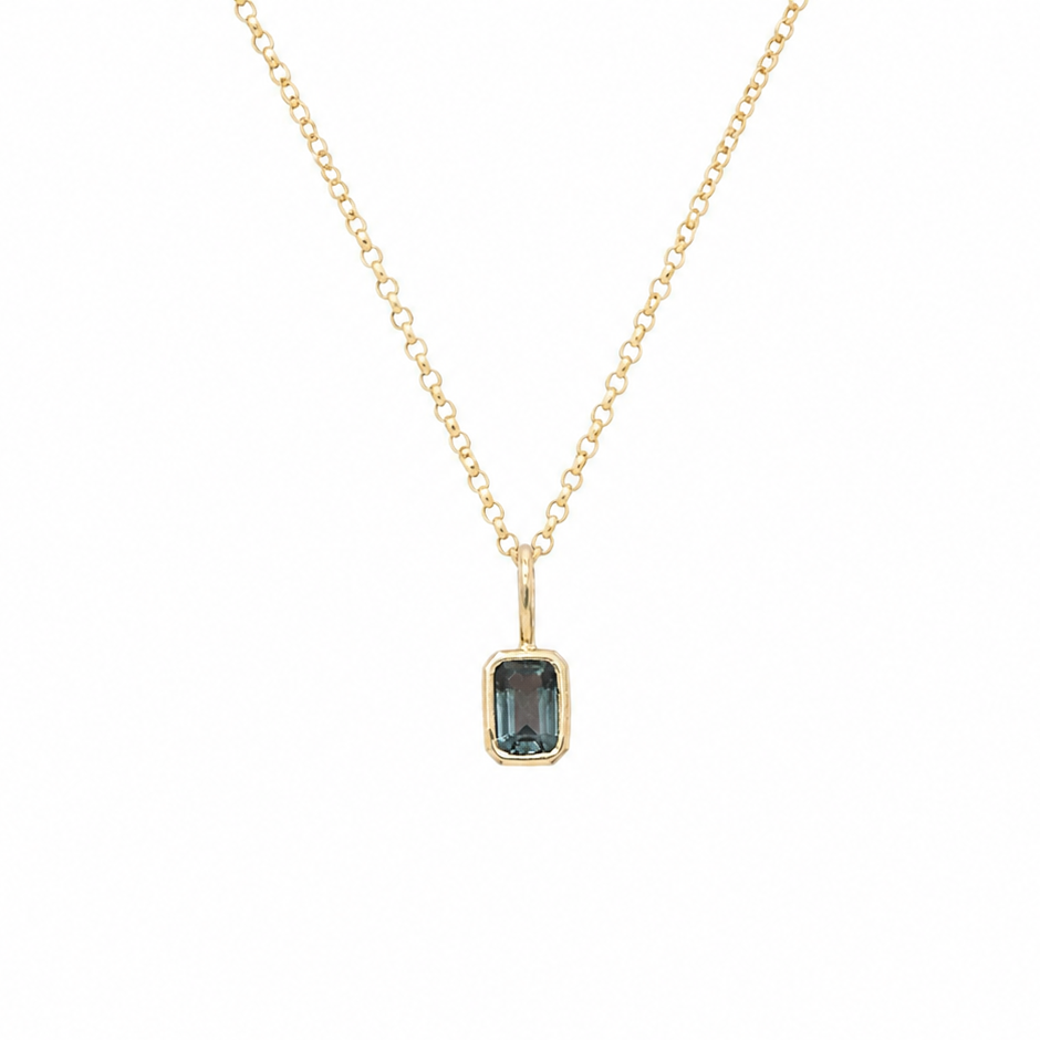 14 karat yellow gold pendant featuring a light blue spinel gemstone in a minimalist bezel setting on a fine gold chain. 